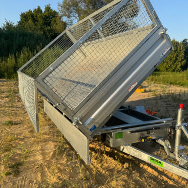 Kippanhänger mit geöffnetem Aufbau, Ladefläche nach hinten gekippt, um Material abzuladen.