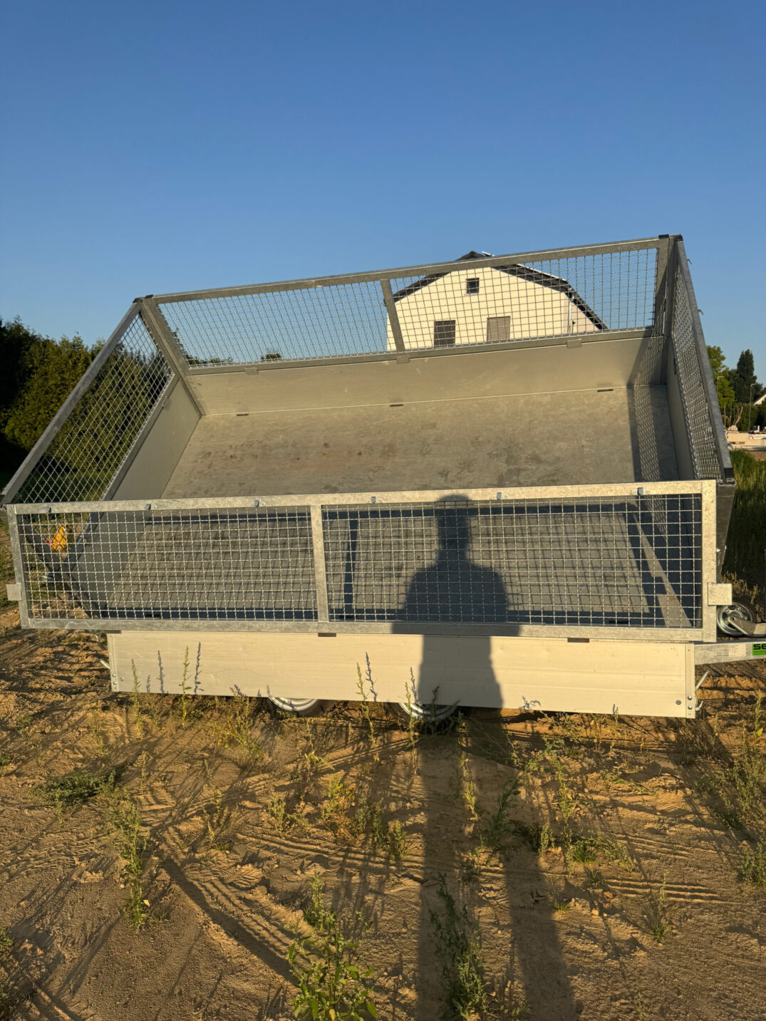 Frontalansicht des nach hinten gekippten Kippanhängers, Blick auf die leere Ladefläche.