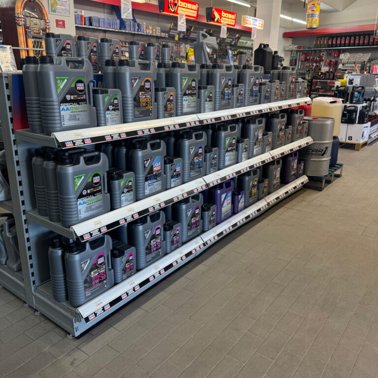Mehrere Regalböden mit Motorölkanistern in verschiedenen Viskositäten der Marke Liqui Moly.