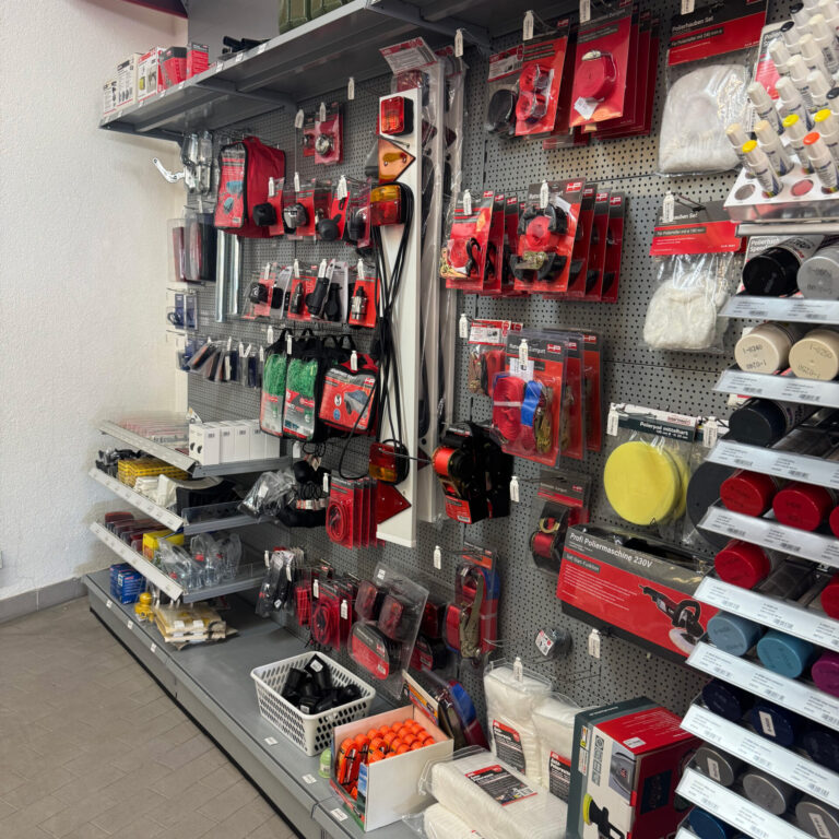 Hakenwand mit Anhängerzubehör, Lampen, Spanngurten und Polierpads.