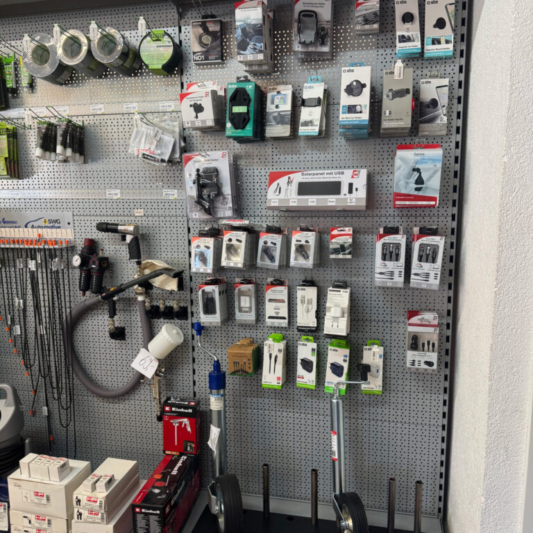Regal mit Steckdosen, Adaptern, Ladegeräten und Stützrädern für Anhänger.