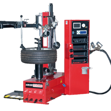 Reifenmontiermaschine in roter Ausführung mit montiertem Autoreifen. Die Maschine verfügt über mehrere mechanische Arme, eine Steuereinheit mit Display und Bedienelementen sowie integrierten Stauraum für Werkzeuge.