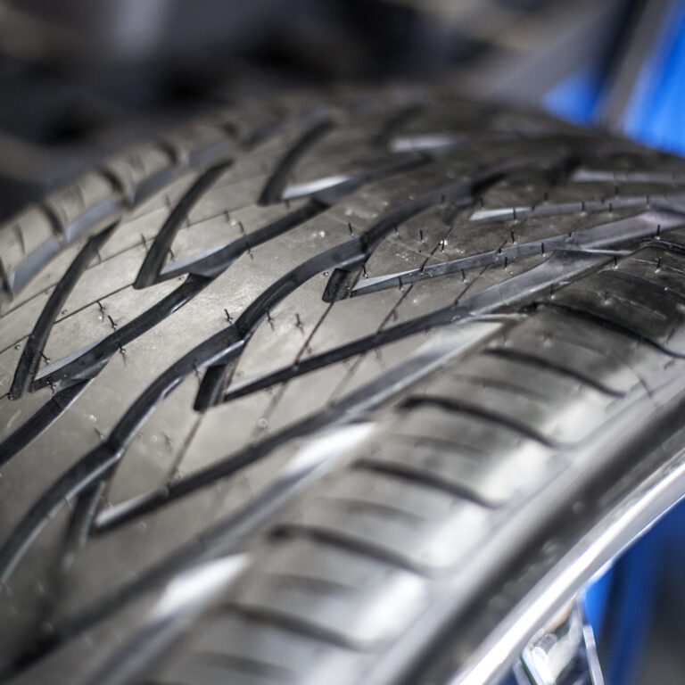 Detailaufnahme eines Autoreifens mit deutlich sichtbarem Profil – Fokus auf der Lauffläche für optimale Bodenhaftung.